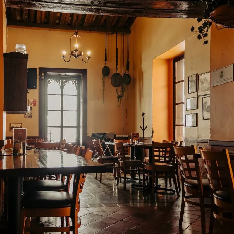 Comedor principal de La Casona del Beaterio, con lámparas cálidas y muros ocres