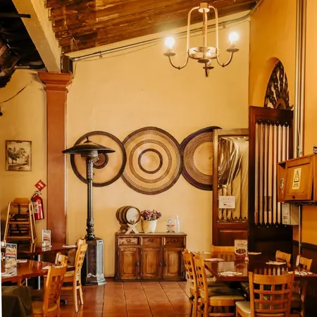 Salón de La Casona con lámparas de forja y muros ocres
