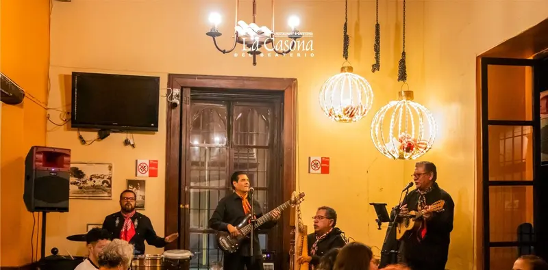 Grupo tocando en vivo entre las mesas de La Casona